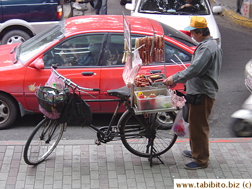 Sausage hawker doing business from the back of his bike