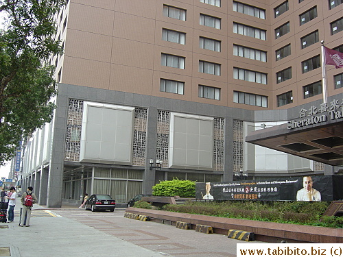 KL waits for the airport bus in front of our hotel