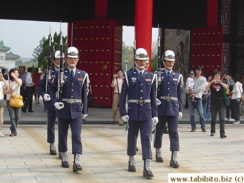 A band of guards start from the main arch entrance and have already marched down the long distance to reach the gates in front of the shrine building