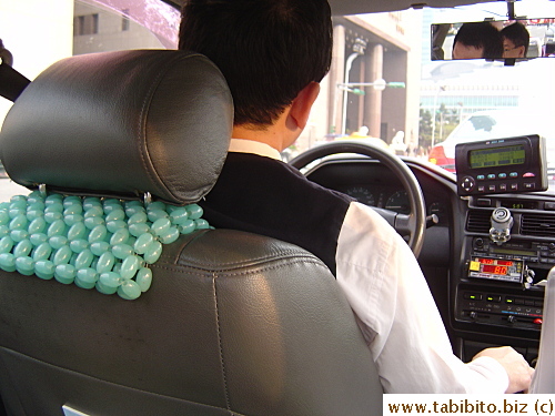 Our first taxi driver.  Notice his beaded seat cover, similar to those used by Hong Kong cabbies